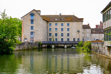 Fototapeta na wymiar Old flour water mill built along the Loing river in Nemours, a small town in the south of the Seine et Marne department in Paris region, France