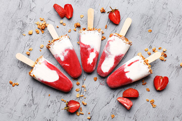 Homemade ice cream popsicles with strawberry and granola on gray concrete background. Overhead view - obrazy, fototapety, plakaty