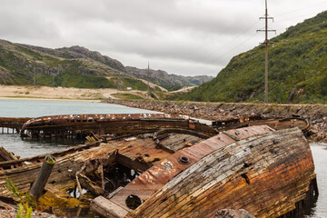 Background on the sea coast near Teriberka. Abandoned rusty ships