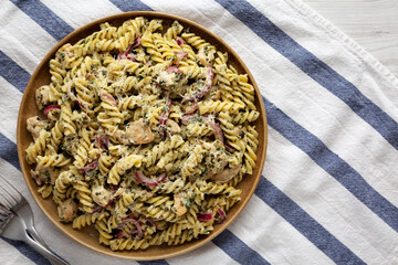Homemade Creamy Lemon Butter Chicken Pasta on a Plate on a white wooden background, top view. Flat lay. Space for text.