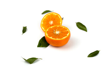 An orange fruit, orange slices, and orange leaves are isolated on a white background.