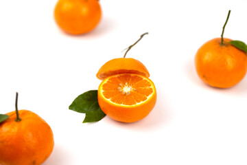 An orange fruit, orange slices, and orange leaves are isolated on a white background.