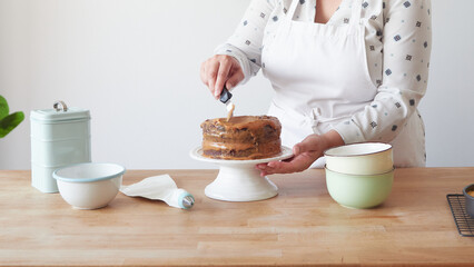 decorating chocolate cake by spreading cream with a spatula