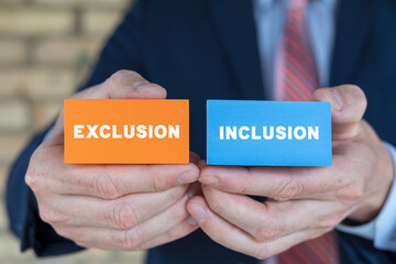Businessman holding colorful styrofoam blocks with inscription: EXCLUSION INCLUSION. Concept of...