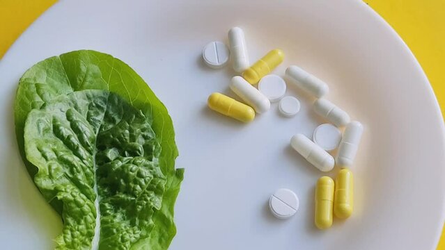 Biological food additives. A person eats capsules lying on a plate with a fork. How to take the pills