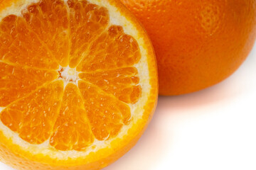 The orange fruit is isolated on a white background with orange slices.