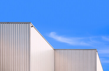 Aluminum Corrugated Industrial Building against blue sky Background in low angle and Perspective side view - obrazy, fototapety, plakaty