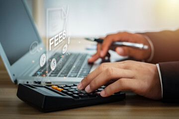 Human hand pressing on calculator and virtual computer screen with word FEES on computer screen....
