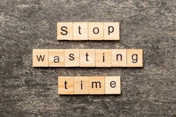 Stop wasting time word written on wood block. Stop wasting time text on cement table for your...