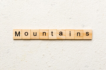 mountains word written on wood block. mountains text on cement table for your desing, concept