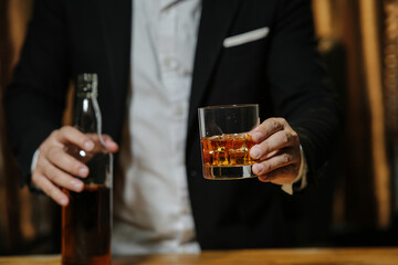 Businessman sitting Holding a Glass of Whiskey Drink Whiskey in the liquor store room