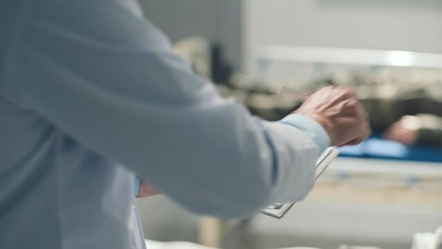 Medium shot of doctor giving document to sign to African American military man with bleeding head wound in hospitalMedium shot of doctor giving document to sign to African American military man with b