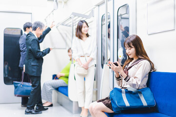 電車・地下鉄で移動する人々