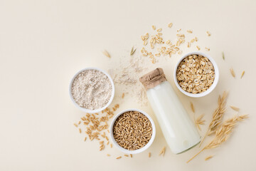 Oat milk, flour, dry flakes and whole grains top view. Set from organic oat products for vegetarian...
