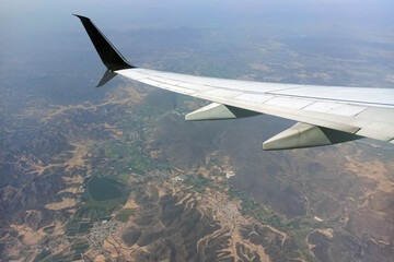 View through airplane window of commercial jet plane wing flying high in the sky. Air travelling...
