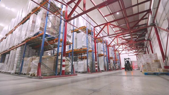 Large warehouse in the factory. The forklift is driving through the warehouse of the factory. Modern warehouse.Warehouse work