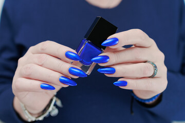 Woman's beautiful hand with long nails and bright blue manicure