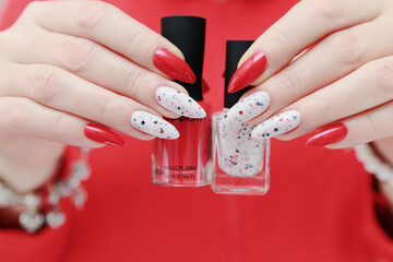 Female hands with long nails and bright red and white manicure
