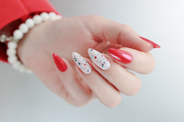 Female hands with long nails and bright red and white manicure