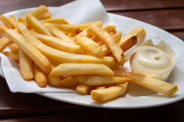 Eating of street or take away food fresh baked french fried potatoes chips with Belgian mayonnaise