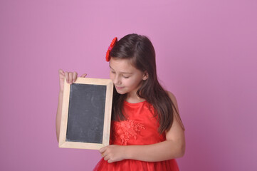 criança menina estudante segurando losa para escrever