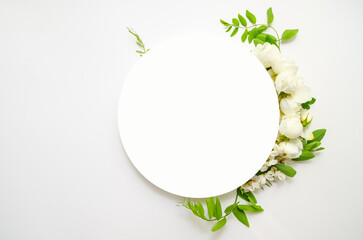 Top view vertical photo of white circle and fresh flowers, white roses on isolated light beige background with blank space