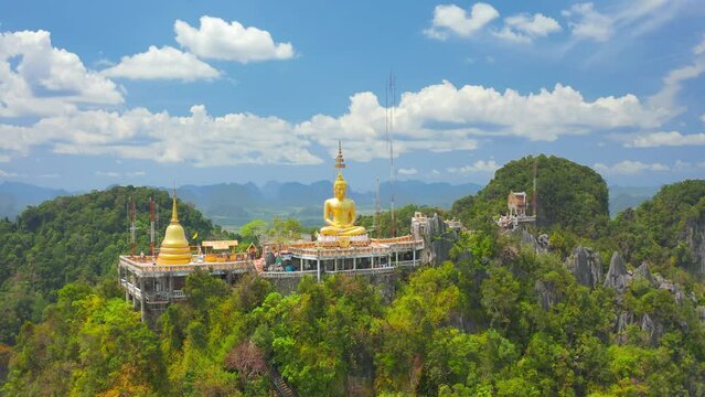Aerial view Tiger Cave Temple, Buddha on the top Mountain with blue sky of Wat Tham Seua, Krabi,Thailand. Aerial view 4K.