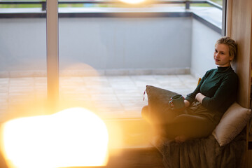 Beautiful girl drinks coffee by the window. Me-time. Time for relaxation.