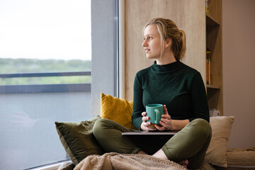 Women's remote work wellness. Work-life balance for women. A woman using laptop in the coziest place.