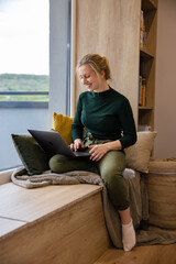 Women's remote work wellness. Work-life balance for women. A woman using laptop in the coziest place.