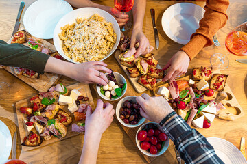 Close-up shot of hands picking Mediterranean appetizers