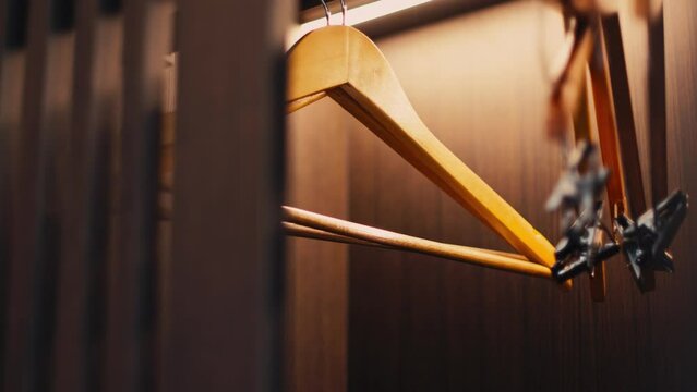 .Hangers in a wooden wardrobe inside the hotel. When opening, there will be a light inside the cabinet that automatically lights up.