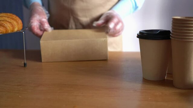 Food delivery services. Restaurant worker collecting a food box take away. Homemade pastry delivery. Cake shop business.