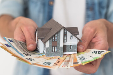 Property buyer holding euro banknotes and buying beautiful flat from real estate agencies on blurred background - obrazy, fototapety, plakaty