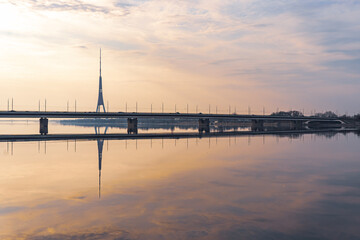 Fototapeta na wymiar sunrise in river Daugava, Riga, reflection of a TV tower and bridge