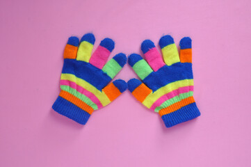 luvas coloridas de inverno em fundo rosa 