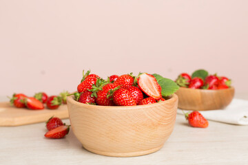 Fresh strawberries in bowl on wooden table