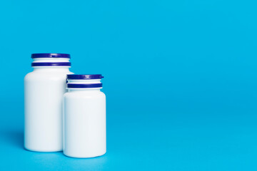 Plastic bottles for vitamins on color background