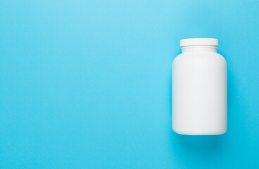 Plastic bottle with vitamins on color background, top view