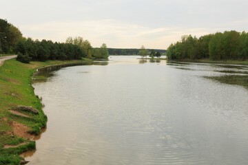 Fototapeta premium Landscape, view of the lake and the shore, green trees and water surface