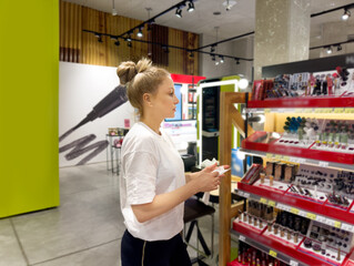 buying make up at cosmetics section in store. choosing cosmetics, perfumes, creams and shampoos, Using tester.