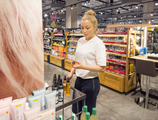 buying make up at cosmetics section in store. choosing cosmetics, perfumes, creams and shampoos, Using tester.