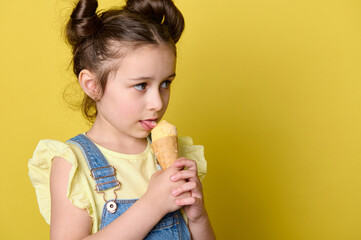 Close-up portrait adorable little child, lovely kid girl 6 years old, licking scoop of yummy ice...