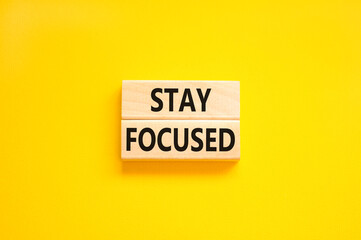 Stay focused symbol. Concept words Stay focused on wooden blocks on a beautiful yellow table yellow background. Business, support, motivation, psychological and stay focused concept. Copy space.