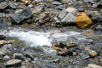 Water flowing over river rocks near mountains in Nathia Gali, Abbottabad, Pakistan.