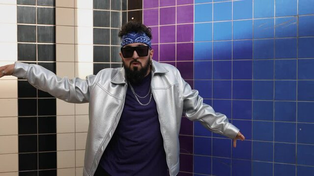 Stylish bearded man in sunglasses performing rnb dance outdoors.