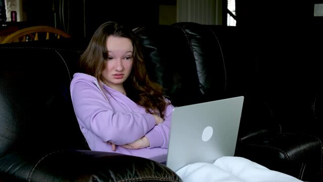 teenage sits on floor watches netflix on big screen of TV screensaver flashes on black background in red blue in hands young woman popcorn 