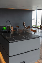 dark minimalistic design of a trendy chic studio apartment with panoramic windows on a high floor overlooking the city