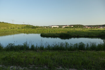 Landscape, view of the lake and the shore, green trees and water surface