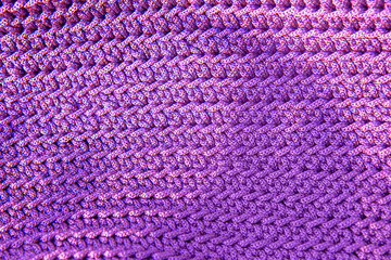 Beautiful knitted violet fabric as background. Needlework as background